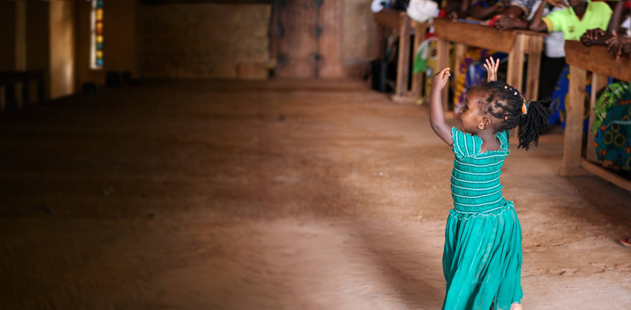 a young girl joyfully dances in her african church